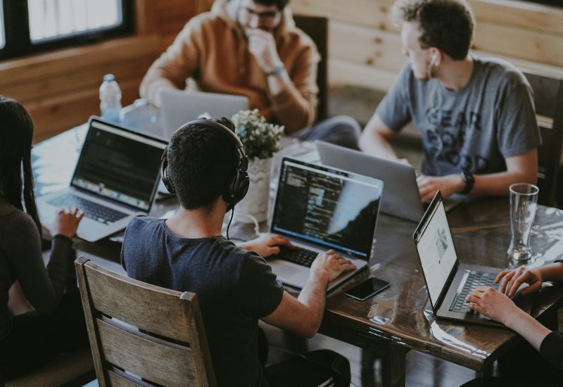 Team working together around a table with laptops