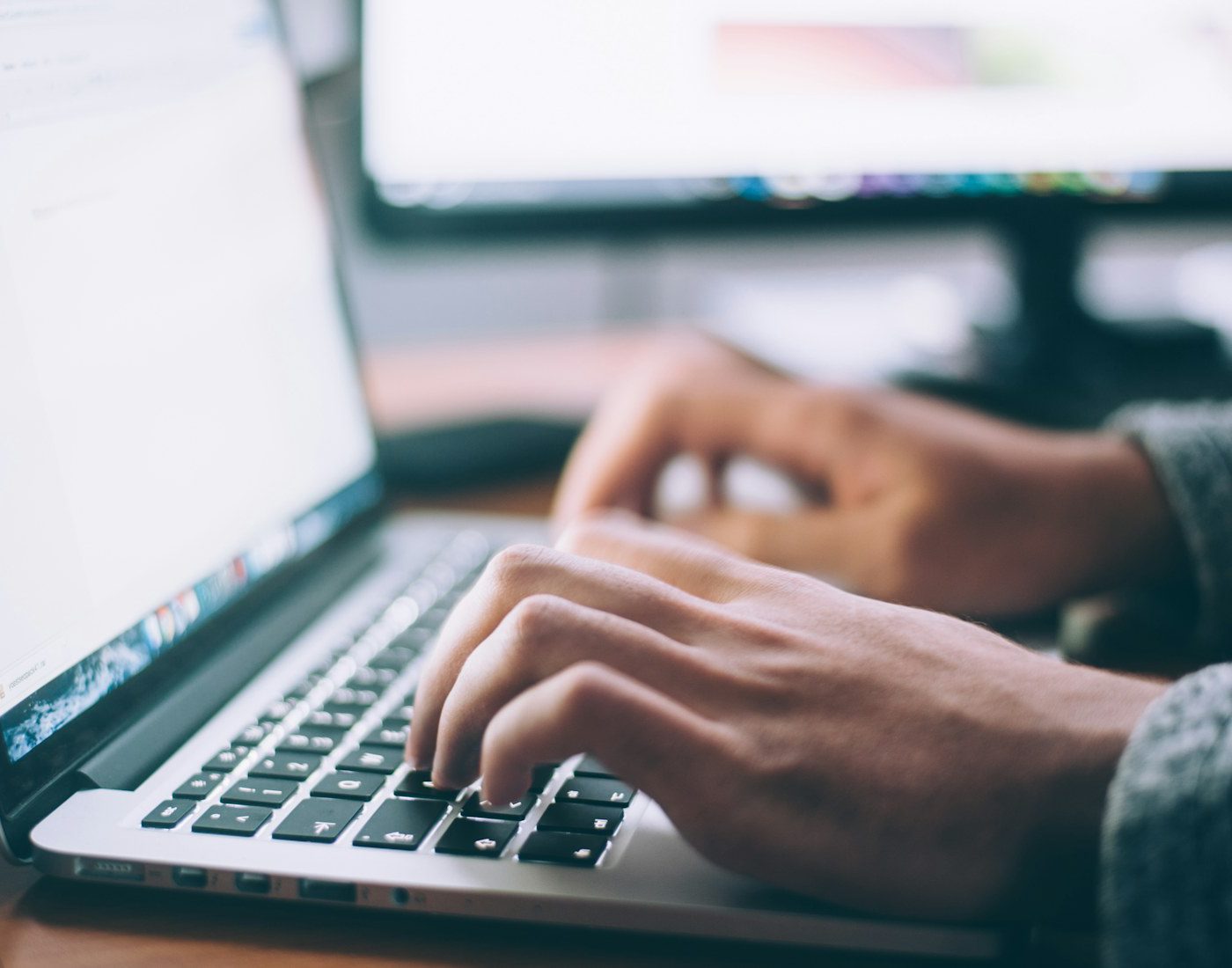 Hands typing on a laptop keyboard