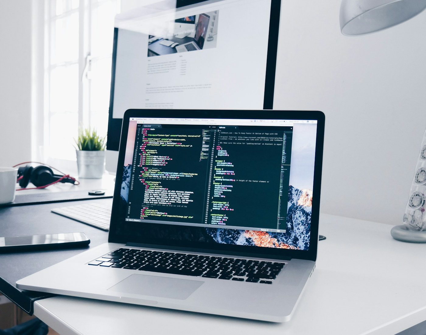 Laptop displaying code in a bright workspace