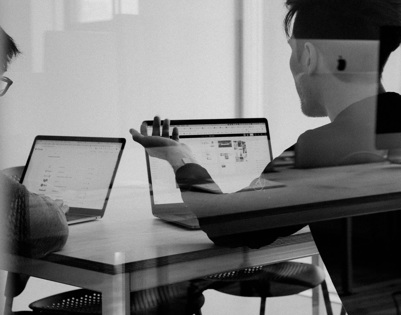 Colleagues reviewing work on a laptop at a desk