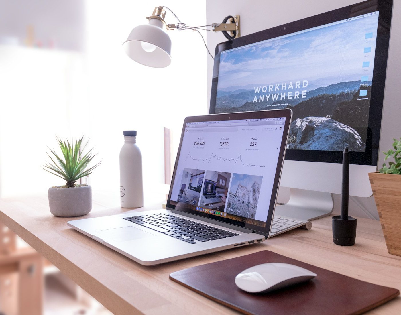 Laptop and desktop monitor showing website layouts
