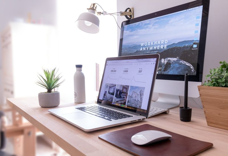 Laptop and desktop monitor showing website layouts